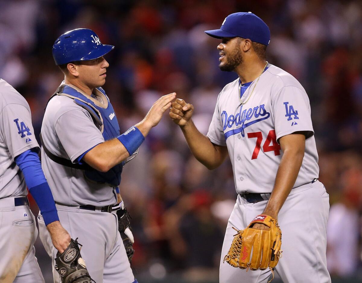 Dodgers closer Kenley Jansen celebrates with catcher A.J. Ellis after beating the Angels 7-5 Monday night.