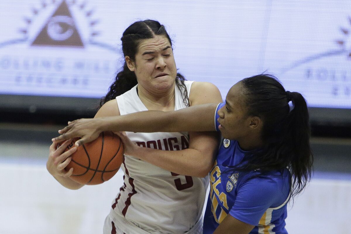 Washington State's Charlisse Leger-Walker, left, handles the ball while being defended by UCLA's Charisma Osborne.