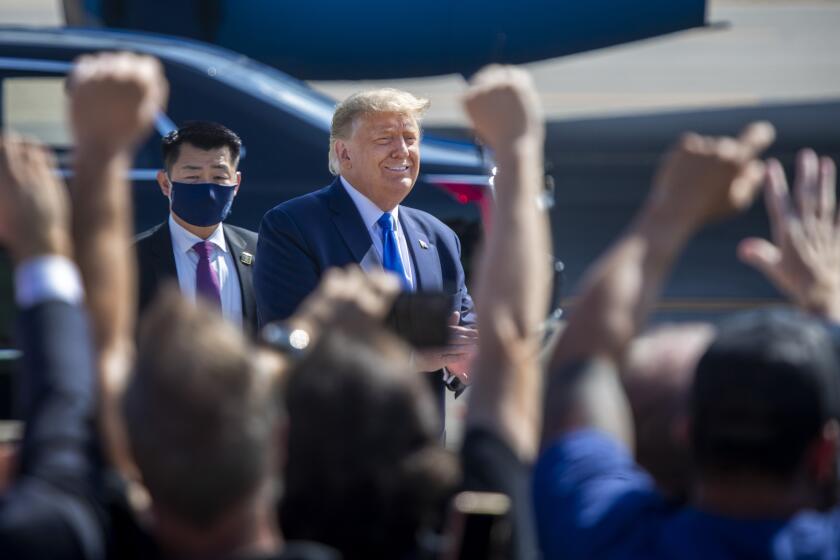 SANTA ANA, CA - OCTOBER 18: President Donald Trump greets supporters as he arrives on Air Force One at John Wayne Airport on Sunday, Oct. 18, 2020 in Santa Ana, where he will be attending a fundraiser at the home of Palmer Luckey on Lido Island in Newport Beach. (Allen J. Schaben / Los Angeles Times)