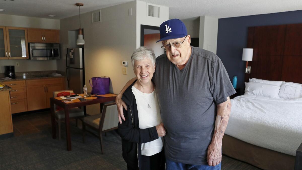 Joan and Harold Leeven stand in the hotel where they're staying after they lost their Huntington Beach home and most of their personal possessions in a fire late July 4.