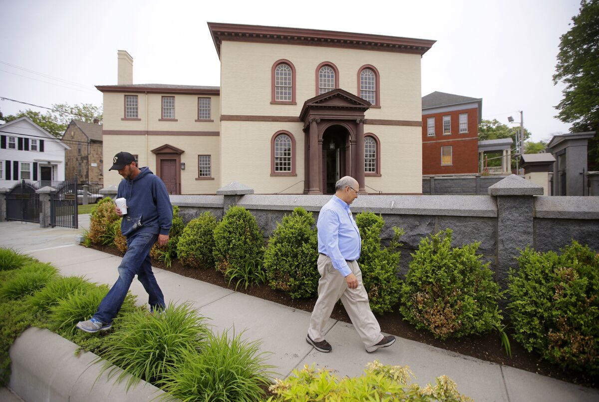 FILE - Employees Chuck Flippo, right, and Asa Montgomery walk through Patriots Park, Thursday, May 28, 2015, at the Touro Synagogue, the nation's oldest, in Newport, R.I. On Monday, Jan. 31, 2022, the New York-based Congregation Shearith Israel filed a court motion to take control of Touro Synagogue by ejecting its current tenants, the Newport-based Congregation Jeshuat Israel. (AP Photo/Stephan Savoia, File)