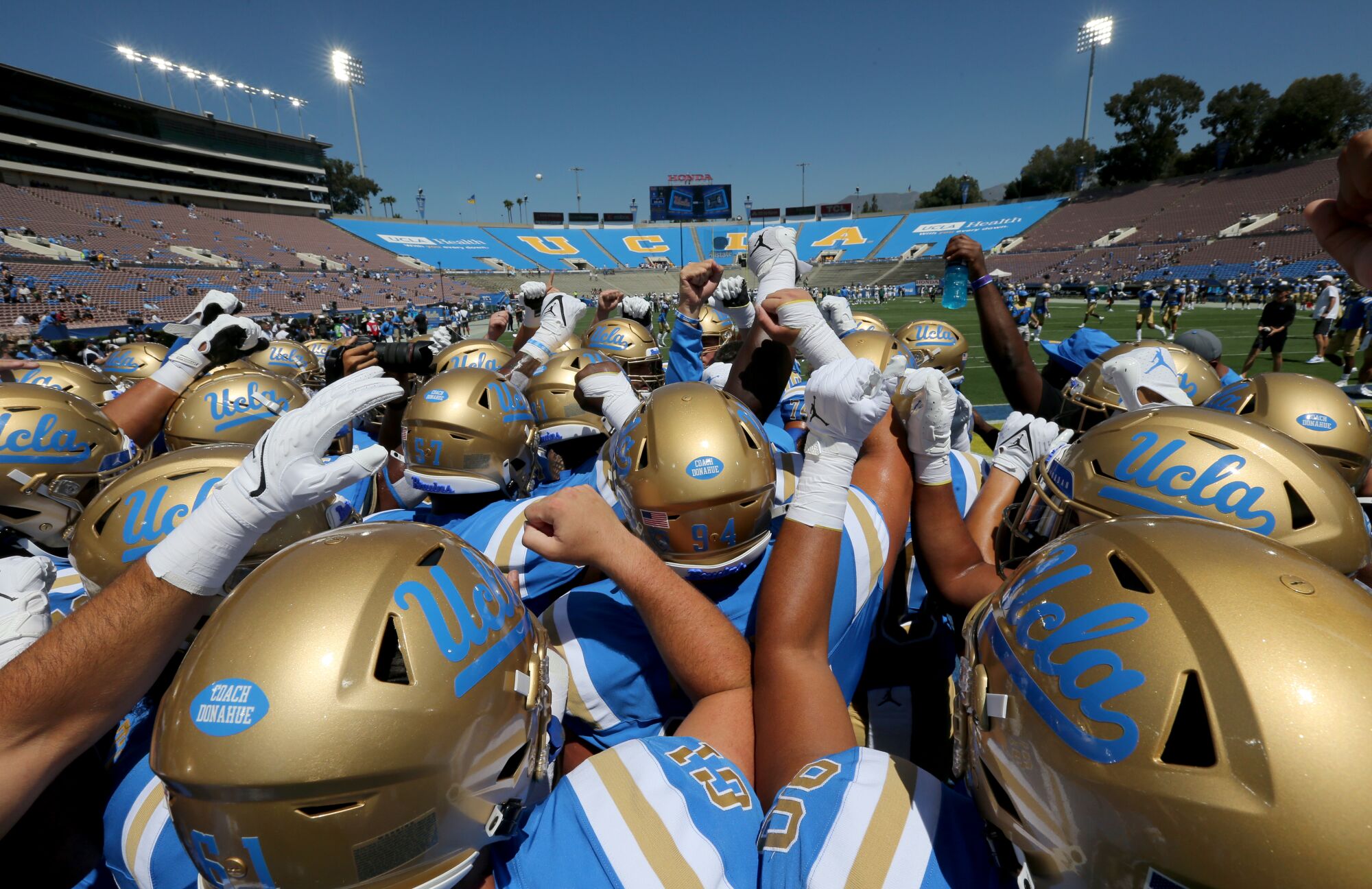 UCLA players huddle before playing Hawaii at the Rose Bowl.