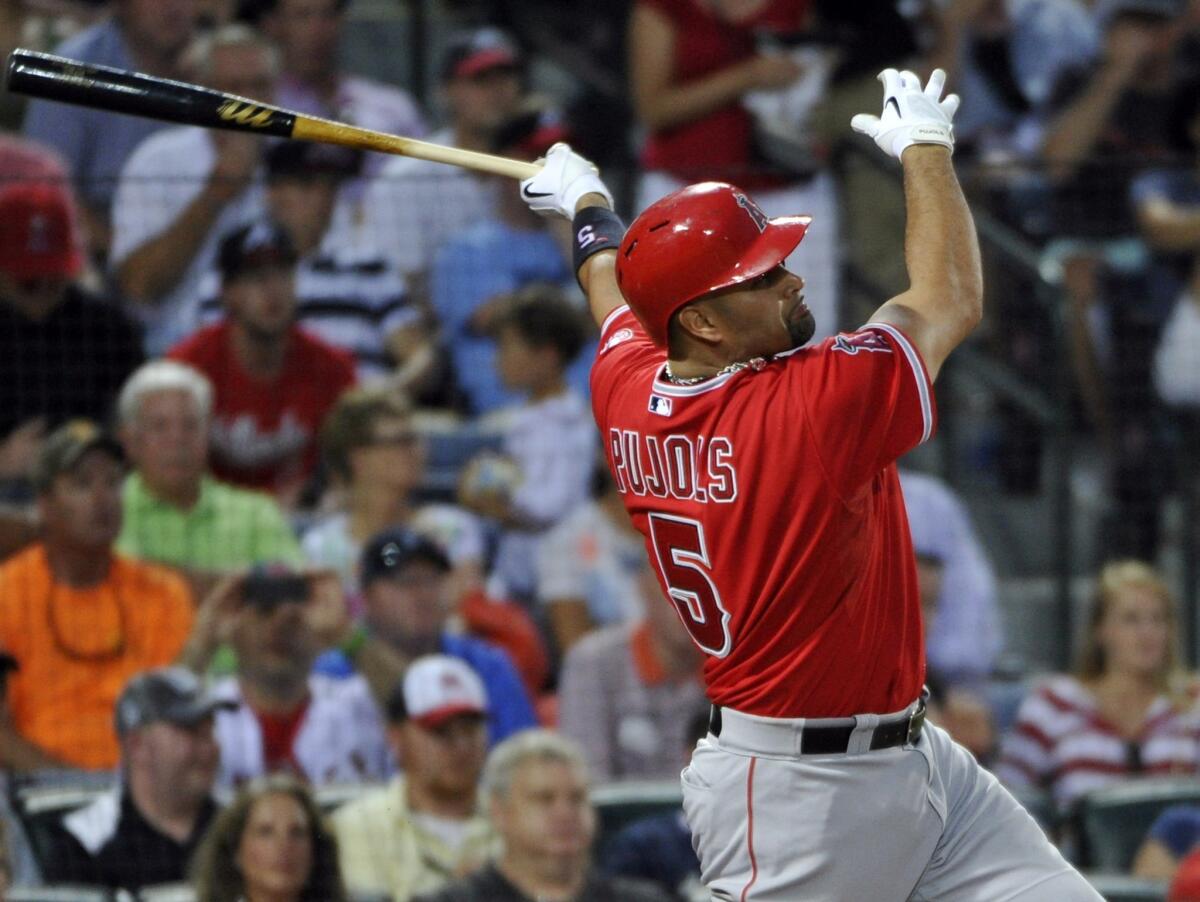 Albert Pujols belts a solo home run against Atlanta Braves pitcher Gavin Floyd in the sixth inning. The Angels defeated the Braves, 11-6, in 13 innings.