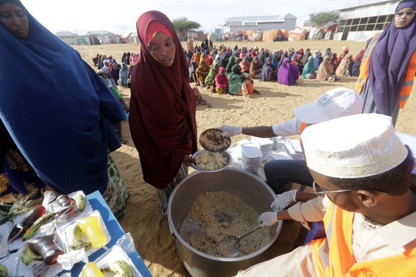 Local NGO prepare Iftar food for people at an internally displaced people camp on the outskirts of Mogadishu, Somalia, Friday, March 24, 2023. This year's holy month of Ramadan coincides with the longest drought on record in Somalia. (AP Photo/Farah Abdi Warsameh)