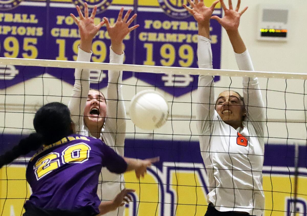 Colleen O'Callaghan (16) and Chara Wondercheck (8) try to block Diamond Bar's Priya George in a volleyball playoff match.