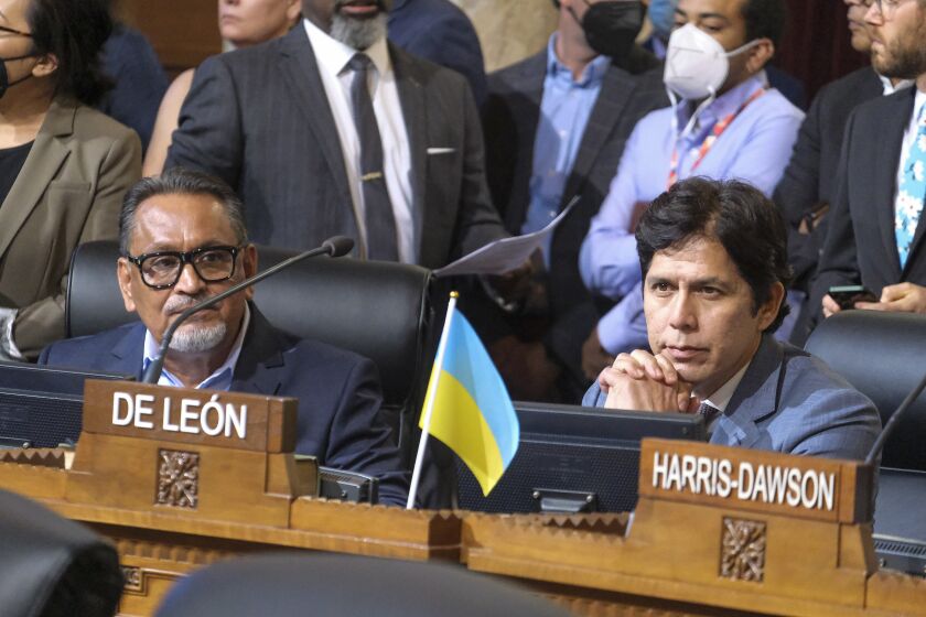 FILE - Los Angeles City Council members Gil Cedillo, left, and Kevin de Leon sit in chamber before starting the Los Angeles City Council meeting on Oct. 11, 2022, in Los Angeles. Embattled Los Angeles councilman Kevin de León attended his first city council meeting Friday, Dec. 9, 2022 in nearly two months since a scandal broke over racist remarks by elected officials. Cedillo was ousted in a June election that predates the scandal. Cedillo's last day in office is Monday. (AP Photo/Ringo H.W. Chiu, File)
