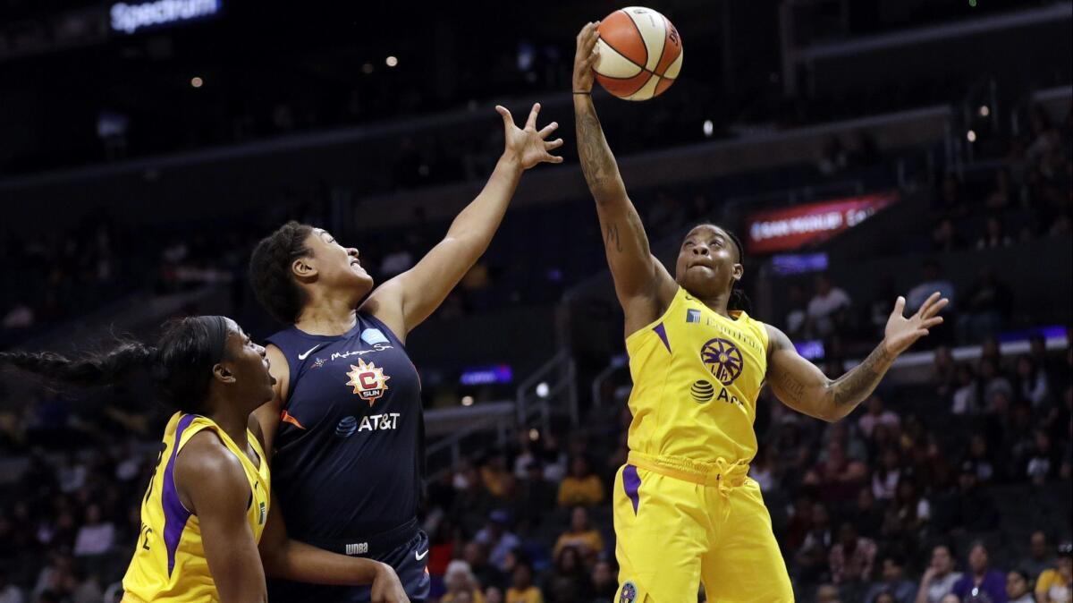 Sparks' Riquna Williams, right, grabs a rebound next to Connecticut Sun's Morgan Tuck, center, during the first half on Friday at Staples Center.