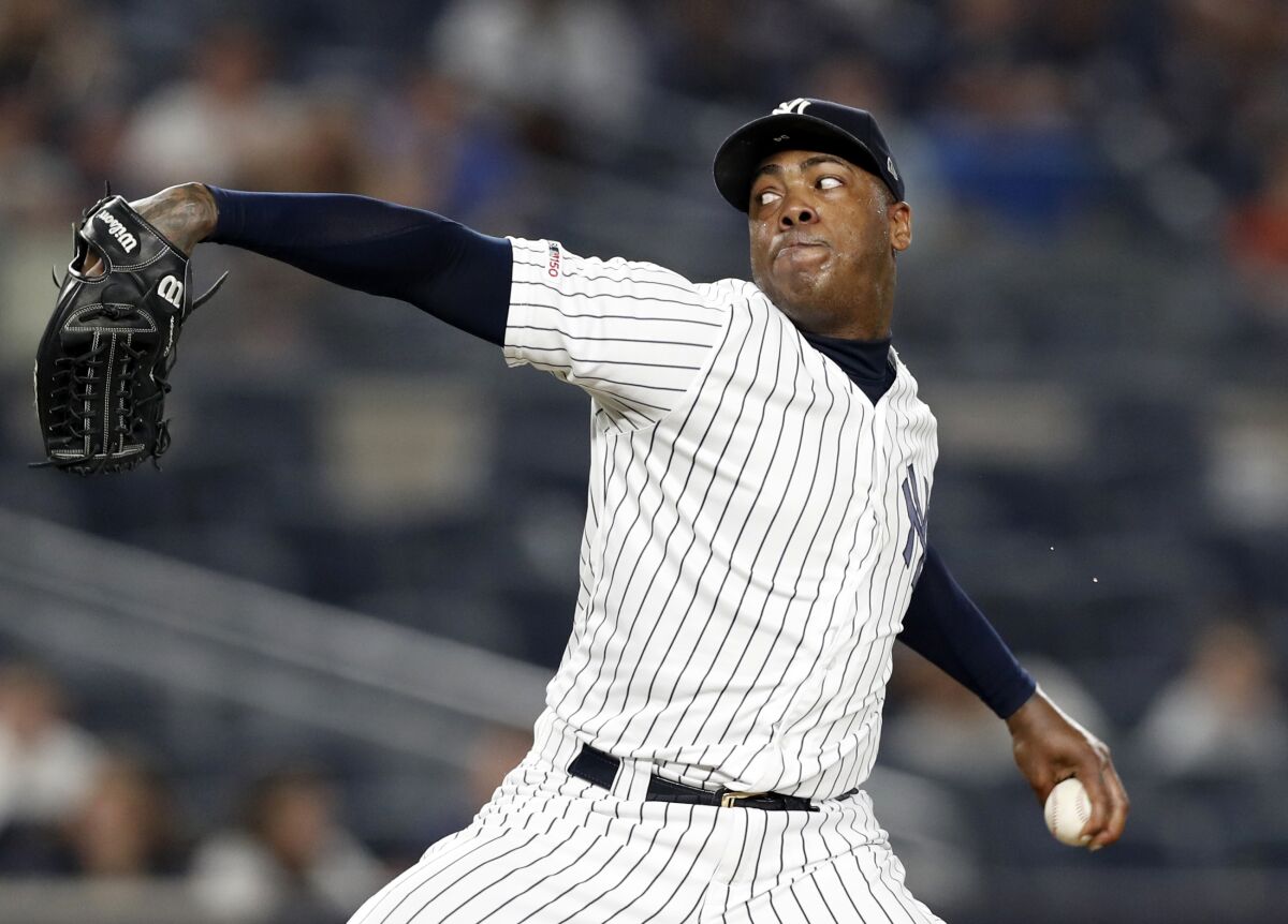 FILE - In this June 24, 2019, file photo, New York Yankees closer Aroldis Chapman winds up in the ninth inning of a baseball game against the Toronto Blue Jays in New York. Yankees manager Aaron Boone announced Saturday, July 11, 2020, that Chapman has tested positive for the coronavirus and is experiencing mild symptoms. (AP Photo/Kathy Willens, File)