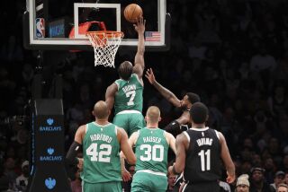 El base de los Celtics de Boston Jaylen Brown bloquea el tiro del alero de los Nets de Brooklyn Royce O'Neale mientras observan Al Horford y Sam Hauser de los Celtics y Kyrie Irving de los Nets en el encuentro del domingo 4 de diciembre del 2022. (AP Foto/Jessie Alcheh)