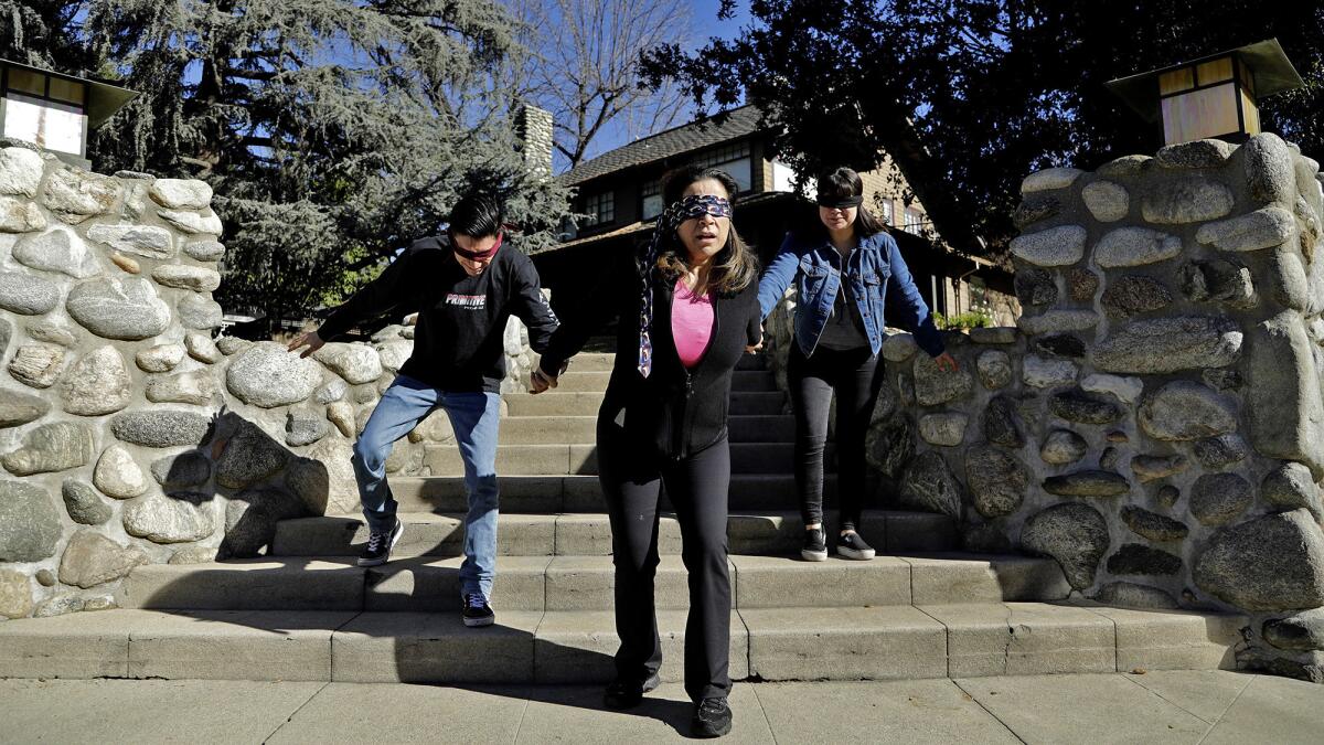 Martha Munguia, center, and her children Rudy Munguia, 23, left, and Alina Munguia, 24, do their best movie recreation at the "Bird Box" house in Monrovia.