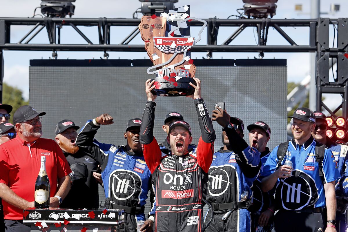 Daniel Suárez celebrates with the winner's trophy after his first career victory at Sonoma Raceway.