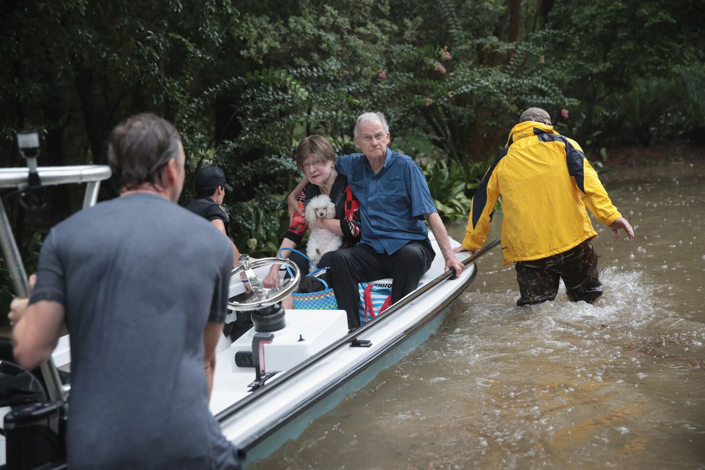 Volunteers and officers from the neighborhood security patrol help rescue residents in Houston's River Oaks neighborhood Sunday.