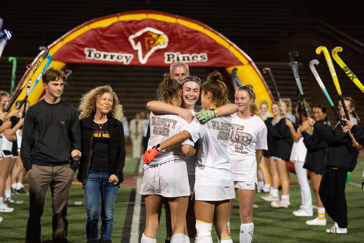 Addison Christie gets a hug from her teammates on senior night,