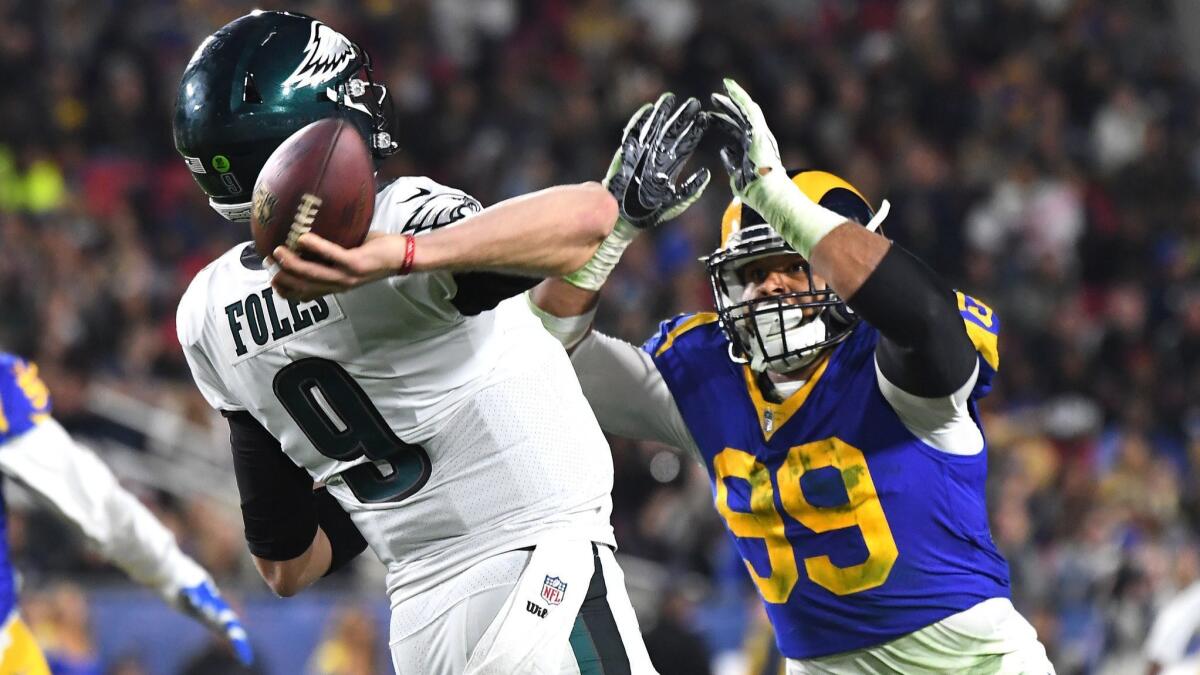 Eagles quarterback Nick Foles gets a pass off despite pressure from Rams defensive tackle Aaron Donald during the second quarter Sunday.