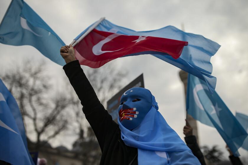 A protester from the Uyghur community living in Turkey waves a Turkish flag during a protest against the visit of China's Foreign Minister Wang Yi to Turkey, in Istanbul, Thursday, March 25, 2021. Hundreds of Uyghurs staged protests in Istanbul and the capital Ankara, denouncing Wang Yi's visit to Turkey and demanding that the Turkish government take a stronger stance against human rights abuses in China's far-western Xinjiang region. (AP Photo/Emrah Gurel)
