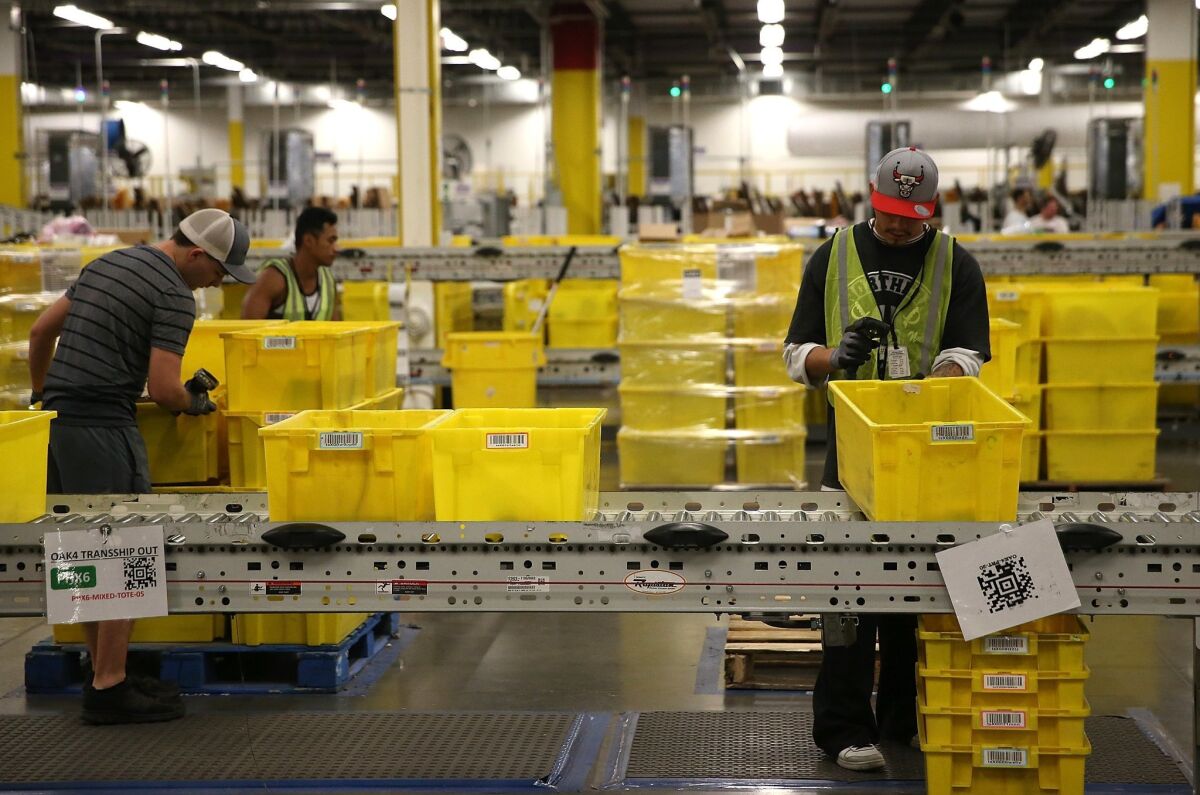 Amazon.com workers pack orders at an Amazon fulfillment center in Tracy, Calif.