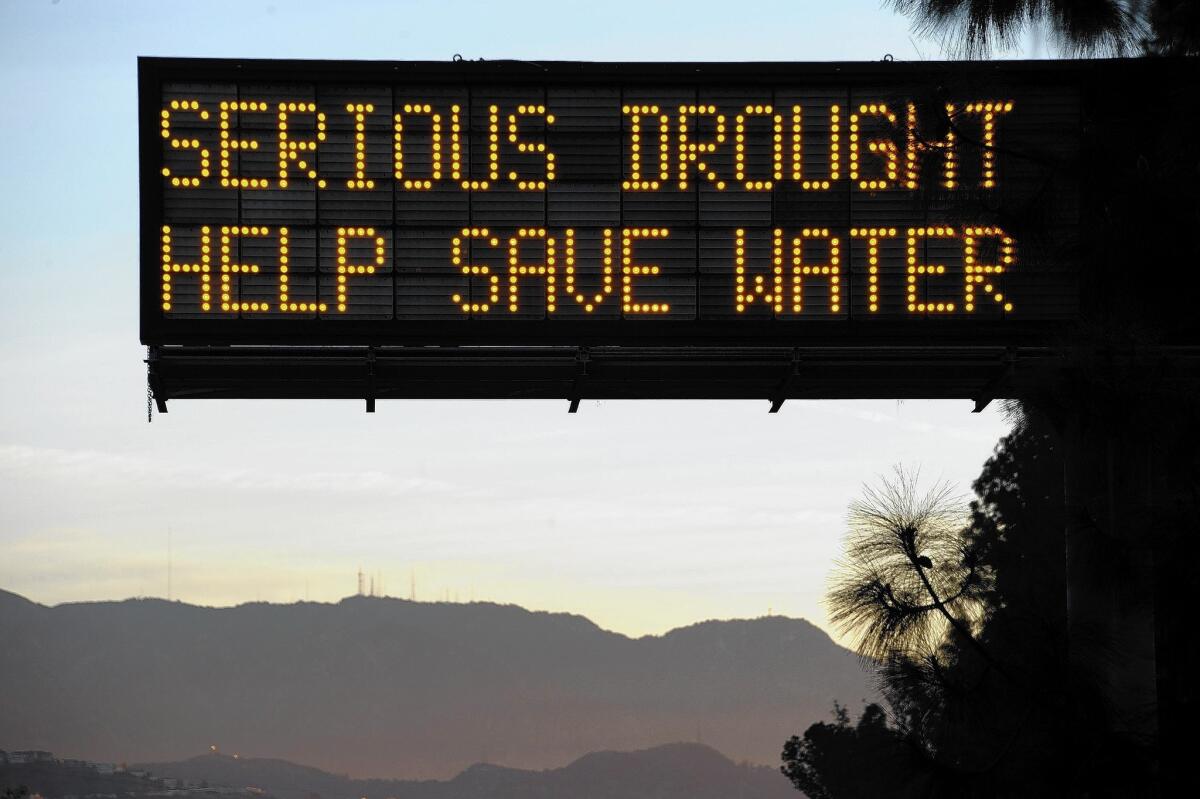 A freeway sign in Glendale advises motorists to save water because of the state's severe drought. One way to do so is to replace water-guzzling grass with drought-tolerant landscaping.