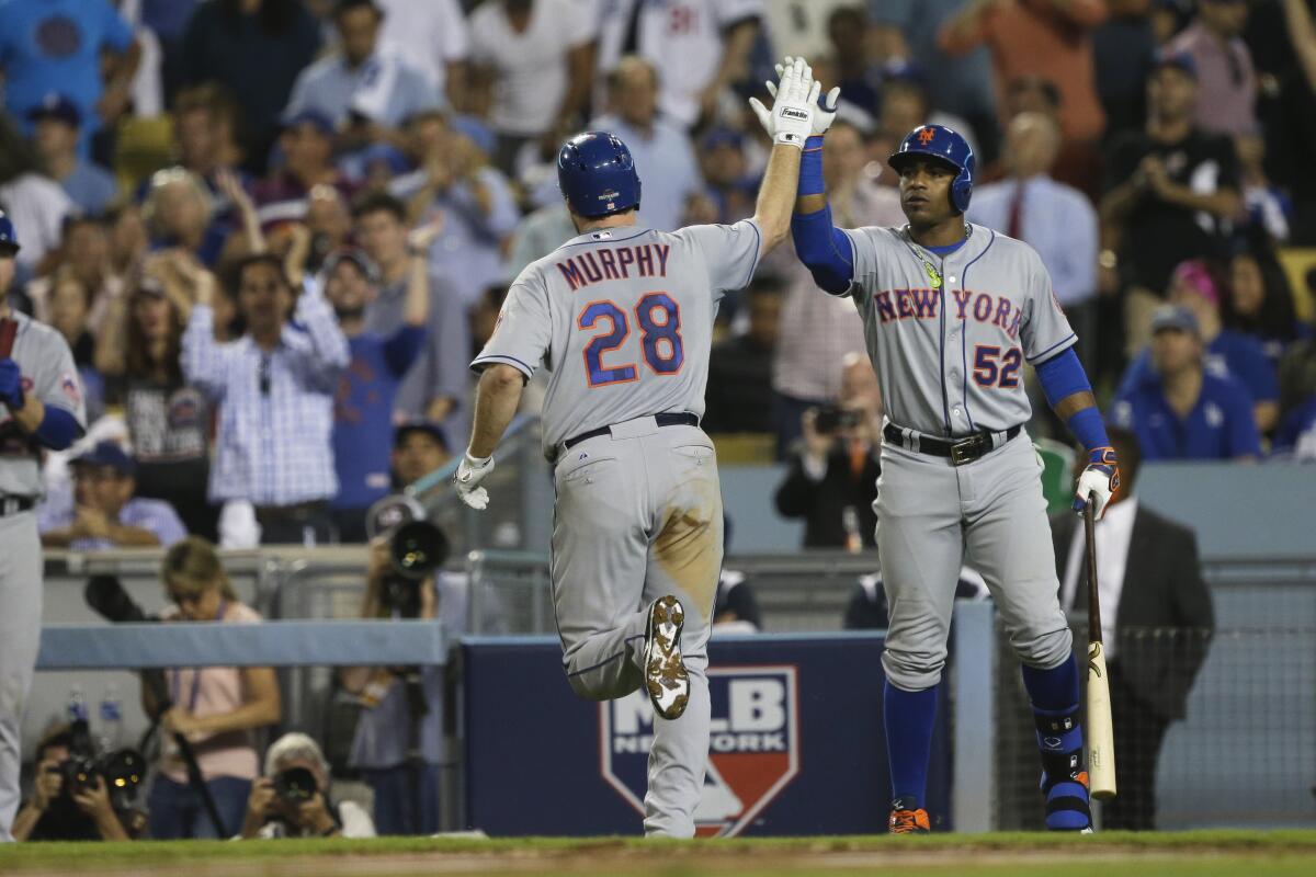 New York Mets' Daniel Murphy gets a high five from teammate Yoenis Cespedes after hitting a home run.