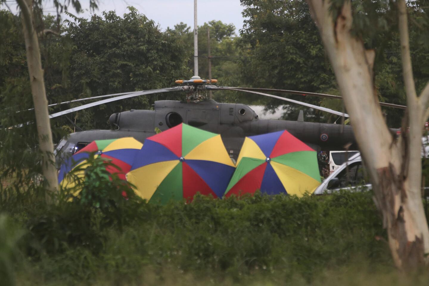 Police place umbrellas around an evacuation helicopter after the last of the trapped boys and their coach were extracted from a cave in Mae Sai, Thailand on July 10.