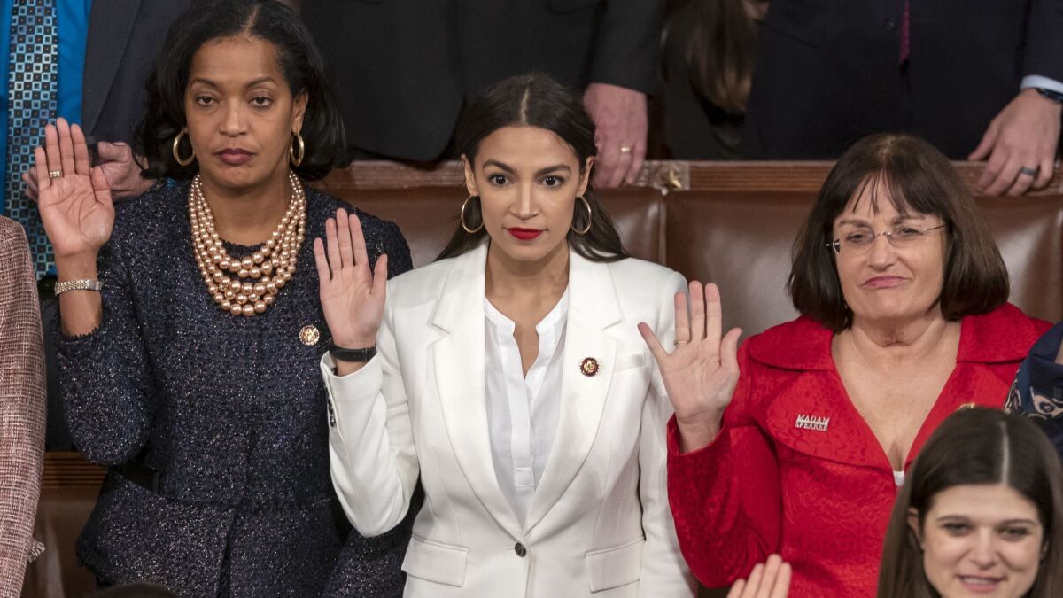 Rep. Alexandria Ocasio-Cortez (D-N.Y.), center, is flanked by Reps. Jahana Hayes (D-Conn.), left, and Ann McLane Kuster (D-N.H.) as they are sworn in on the opening day of the 116th Congress.