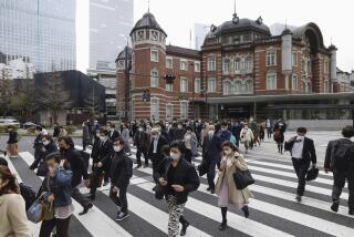 People walk across an intersection near Tokyo Station in Tokyo, Monday, March 13, 2023. Japan is dropping its mask wearing request beginning Monday for the first time in three years as the country further eases COVID-19 rules in public places and tries to expand business and other activity. (Miyuki Saito/Kyodo News via AP)