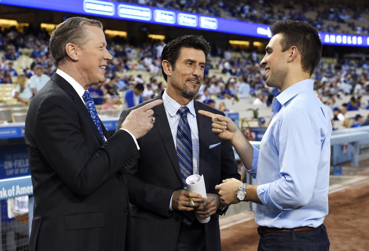 Dodgers broadcasters, from left, Orel Hershiser, Nomar Garciaparra and Joe Davis chat before a game.