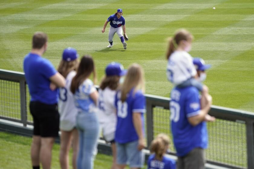Fans watch as Los Angeles Dodgers relief pitcher Ryan Pepiot warms up before a spring training baseball.