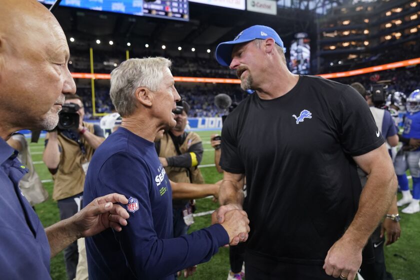 Seattle Seahawks head coach Pete Carroll, left, meets with Detroit Lions head coach Dan Campbell after the second half of an NFL football game, Sunday, Oct. 2, 2022, in Detroit. (AP Photo/Paul Sancya)