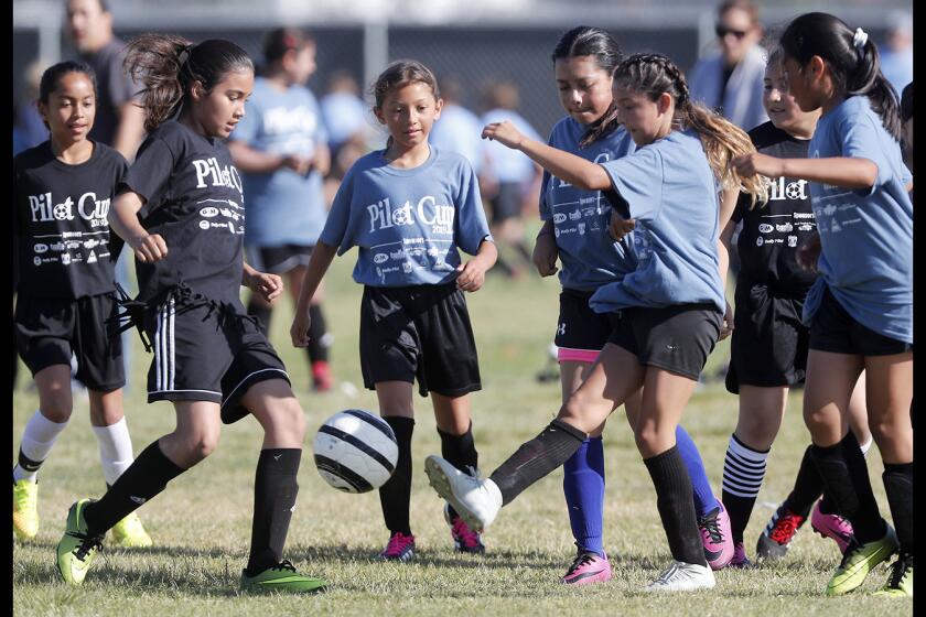 Costa Mesa College Park Elementary's Candice Lankford, right, kicks the ball away from Costa Mesa Rea's Elizabeth Garibay, left, during a girls’ third- and fourth-grade Bronze Division pool-play match at the Daily Pilot Cup on Wednesday at Jack R. Hammett Sports Complex in Costa Mesa.