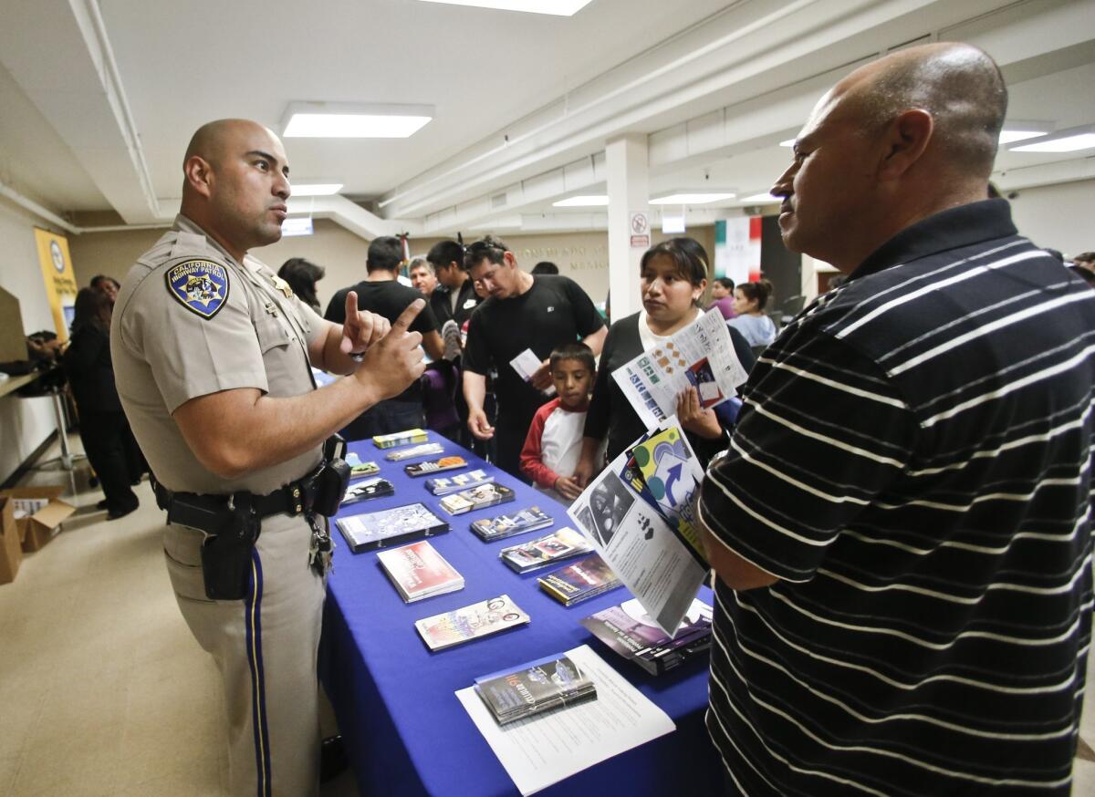 California Highway Patrol officer Armando Garcia explains the process of getting a driver's license during an information session at the Mexican Consulate in San Diego. California will finally begin issuing licenses to those in the country illegally.