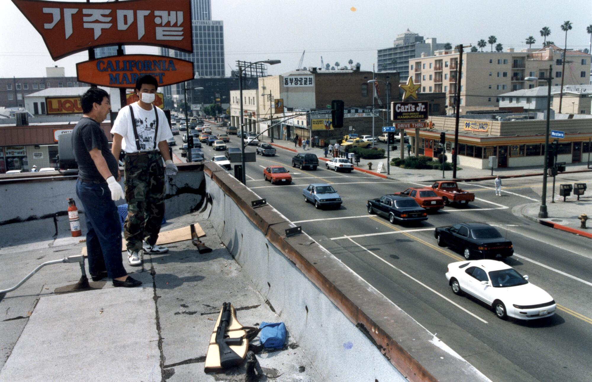 A man, armed with a handgun, on the roof of his grocery store in Koreatown in 1992.