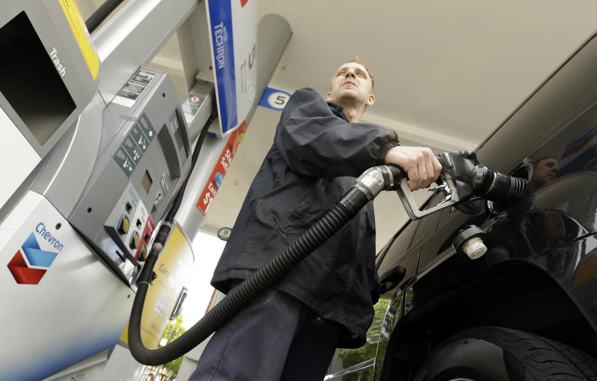 Attendant James Lewis pumps gas at a station in Portland, Ore. on May 6.