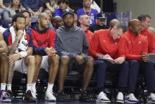 Injured Clippers forward Kawhi Leonard sits on the bench in street clothes during a preseason game