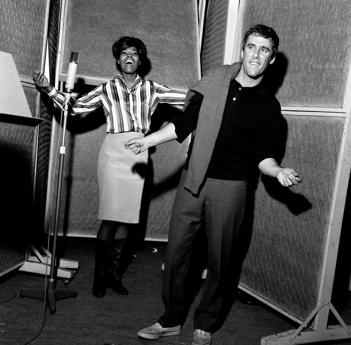 A man and a woman in a recording booth.