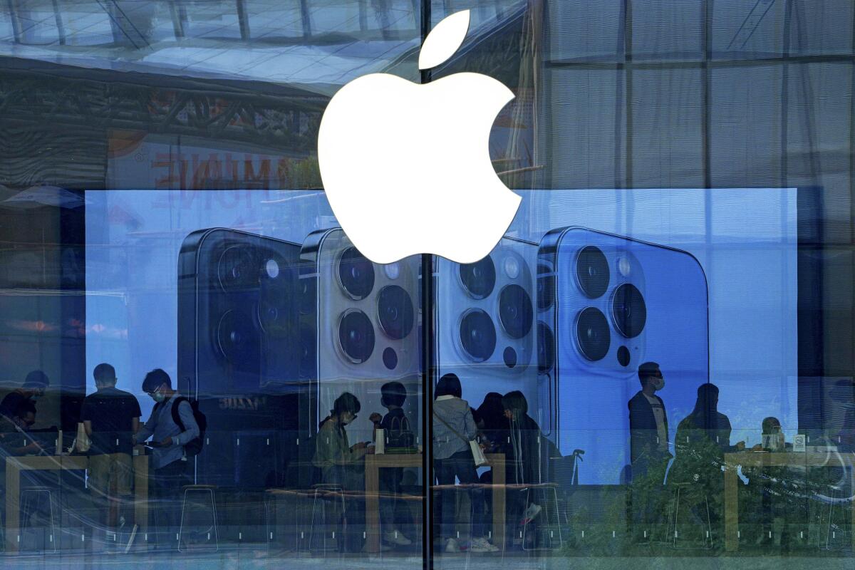  personas prueban los nuevos celulares iPhone 13 en una Apple Store en Beijing. 