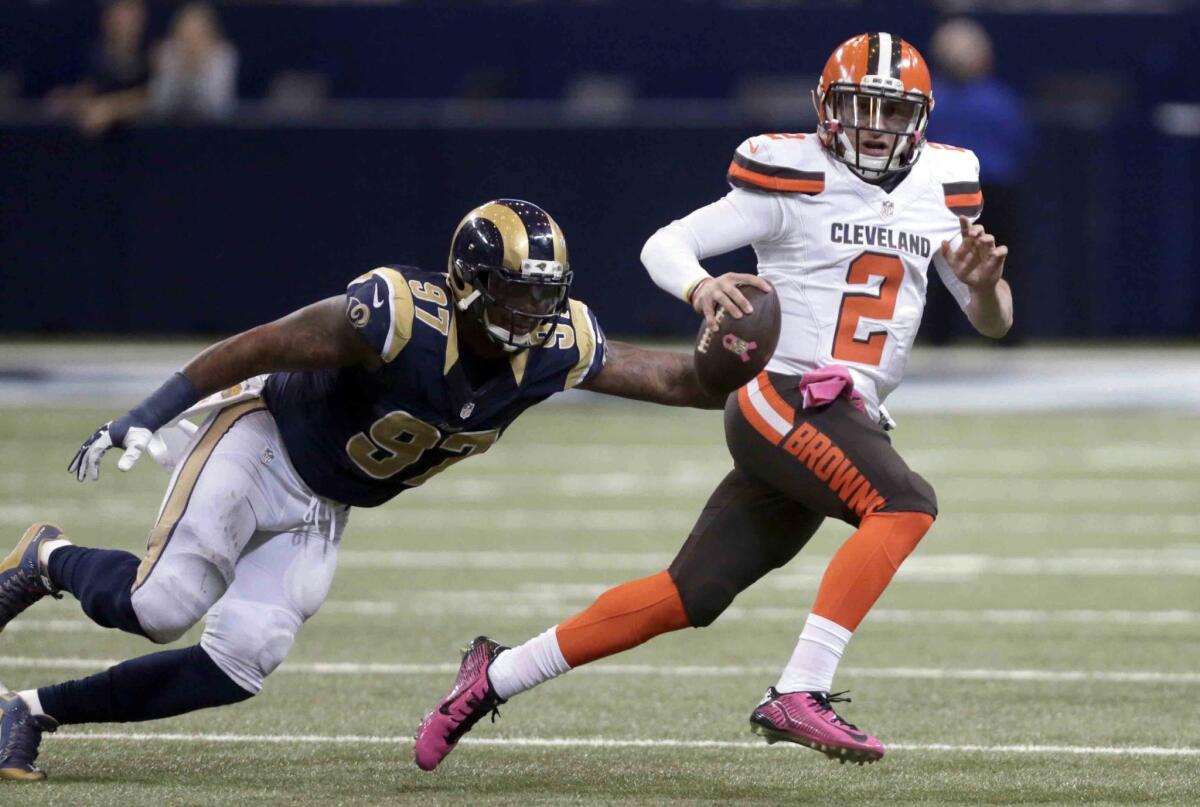 Cleveland Browns quarterback Johnny Manziel, right, runs with the ball as St. Louis Rams defensive end Eugene Sims pursues during the fourth quarter of an NFL football game.