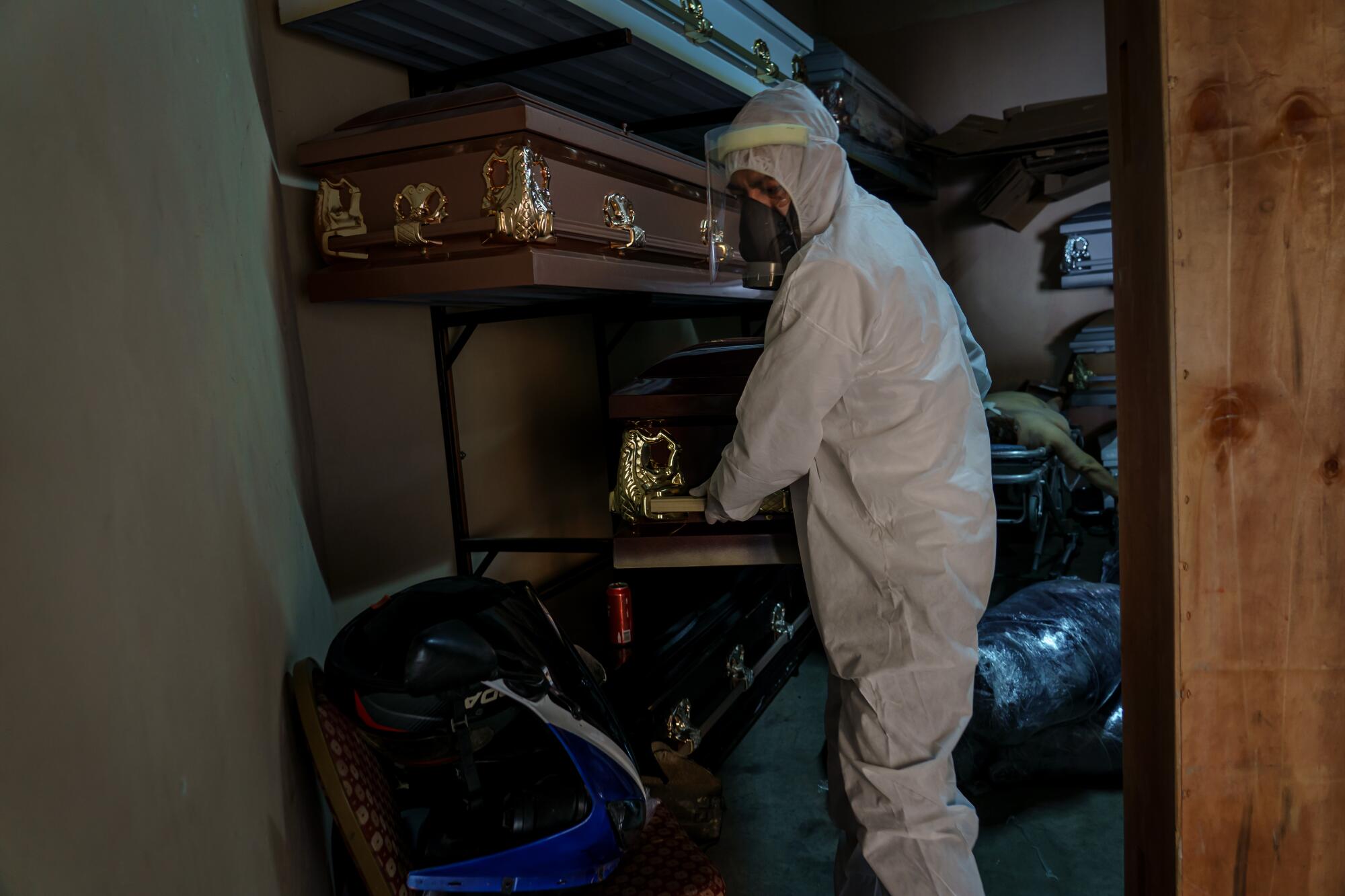 Diego Armando Juarez, a funeral advisor, helps move a casket.