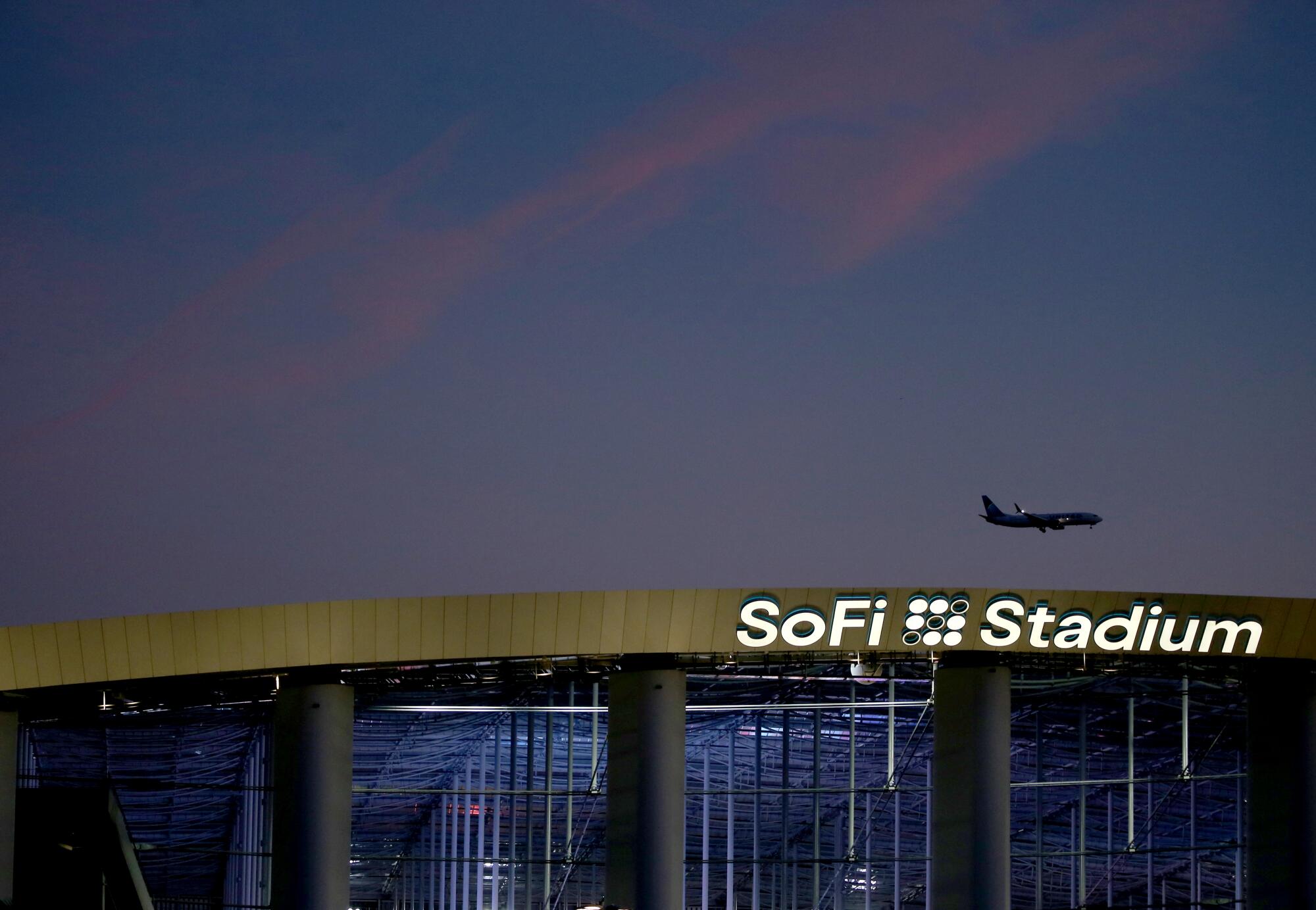 A plane descends over SoFi Stadium