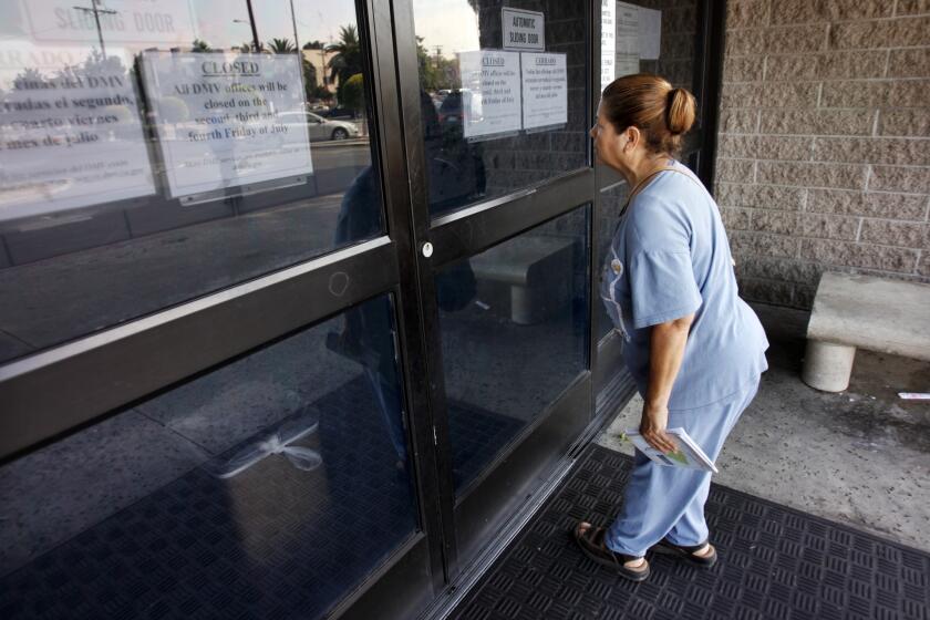 Olga Menendez peers into the dark offices of the Department of Motor Vehicles at 3615 S. Hope Street in Los Angeles. Signs on the door indicate the office is closed due to a furlough day.