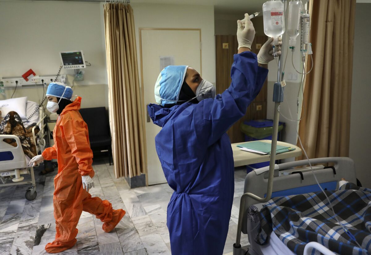 Nurses tend to COVID-19 patients in Tehran hospital in June