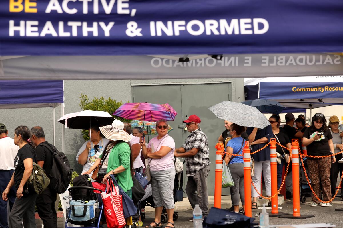 People wait in line to register for a free flu vaccine.