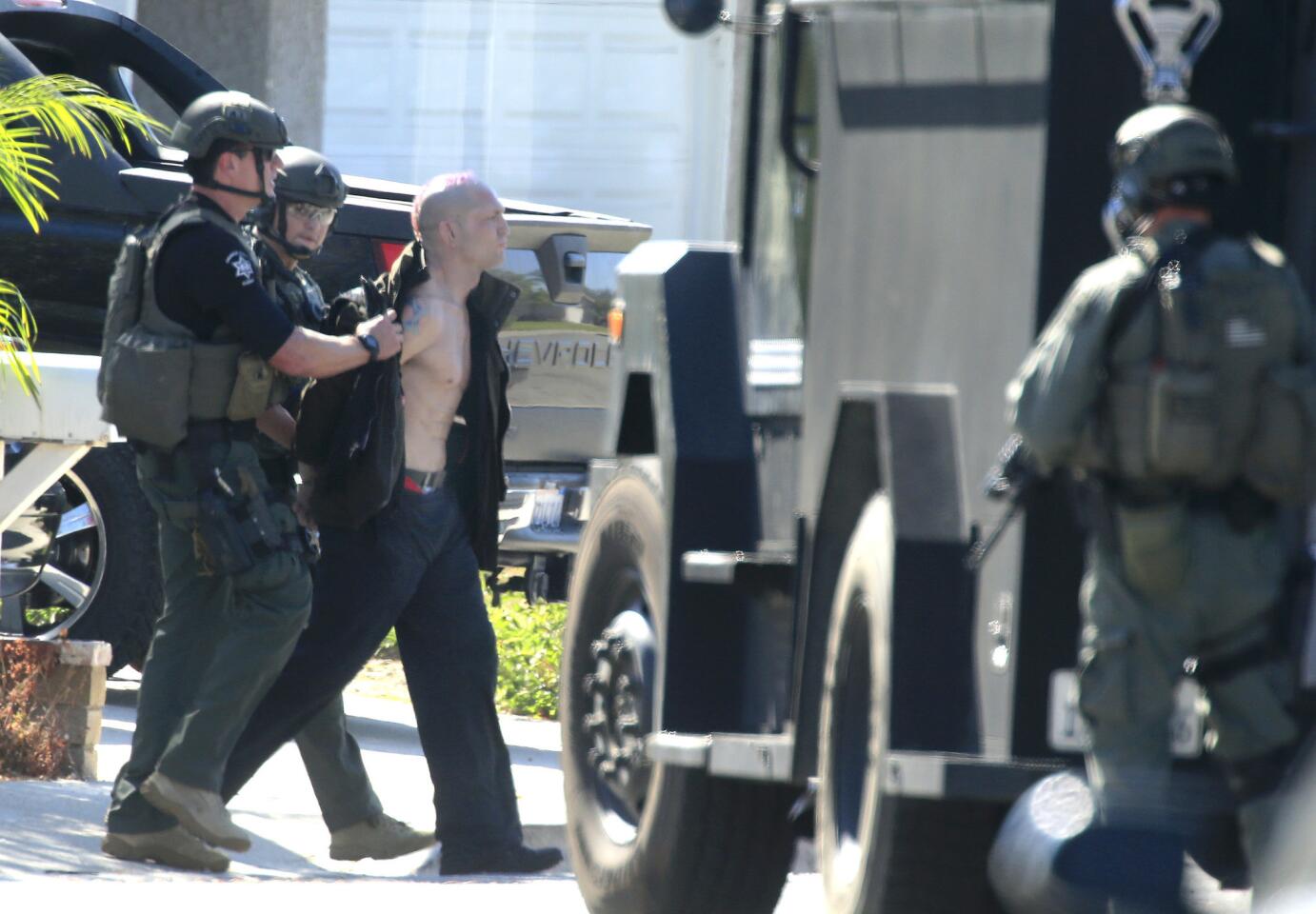 After they fired a flash-bang grenade into the Mission Viejo home, Orange County Sheriff SWAT team members arrest Jason "Mayhem" Miller on Oct. 9.