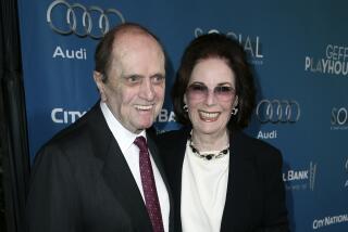 Comedian Bob Newhart smiling next to his wife Ginnie Newhart