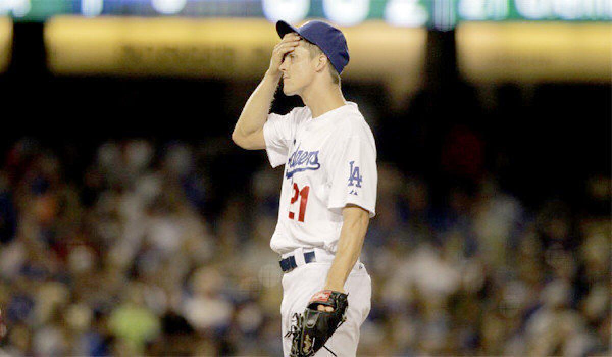 Zack Greinke puts his hand to his forehead after giving up a two-run home run to Cincinnati Reds right fielder Jay Bruce in the sixth inning of the Dodgers' 5-2 loss.