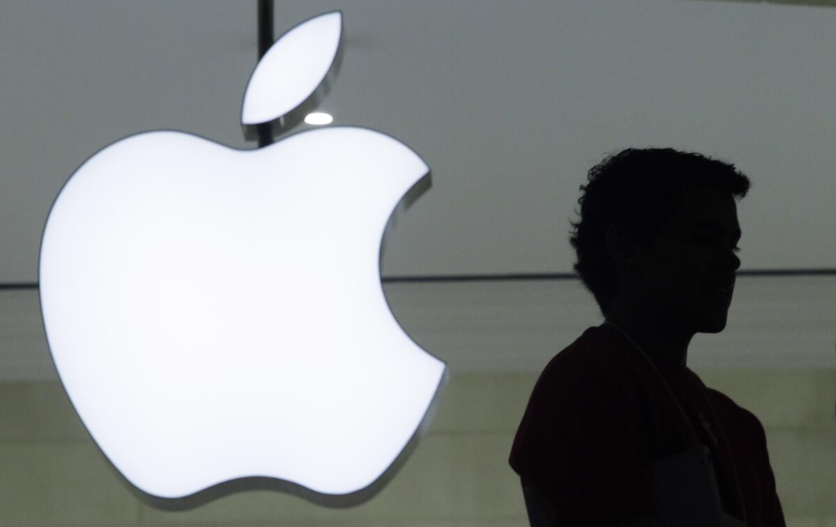 Una persona pasa frente a un logo de Apple en la tienda de la marca en Grand Central