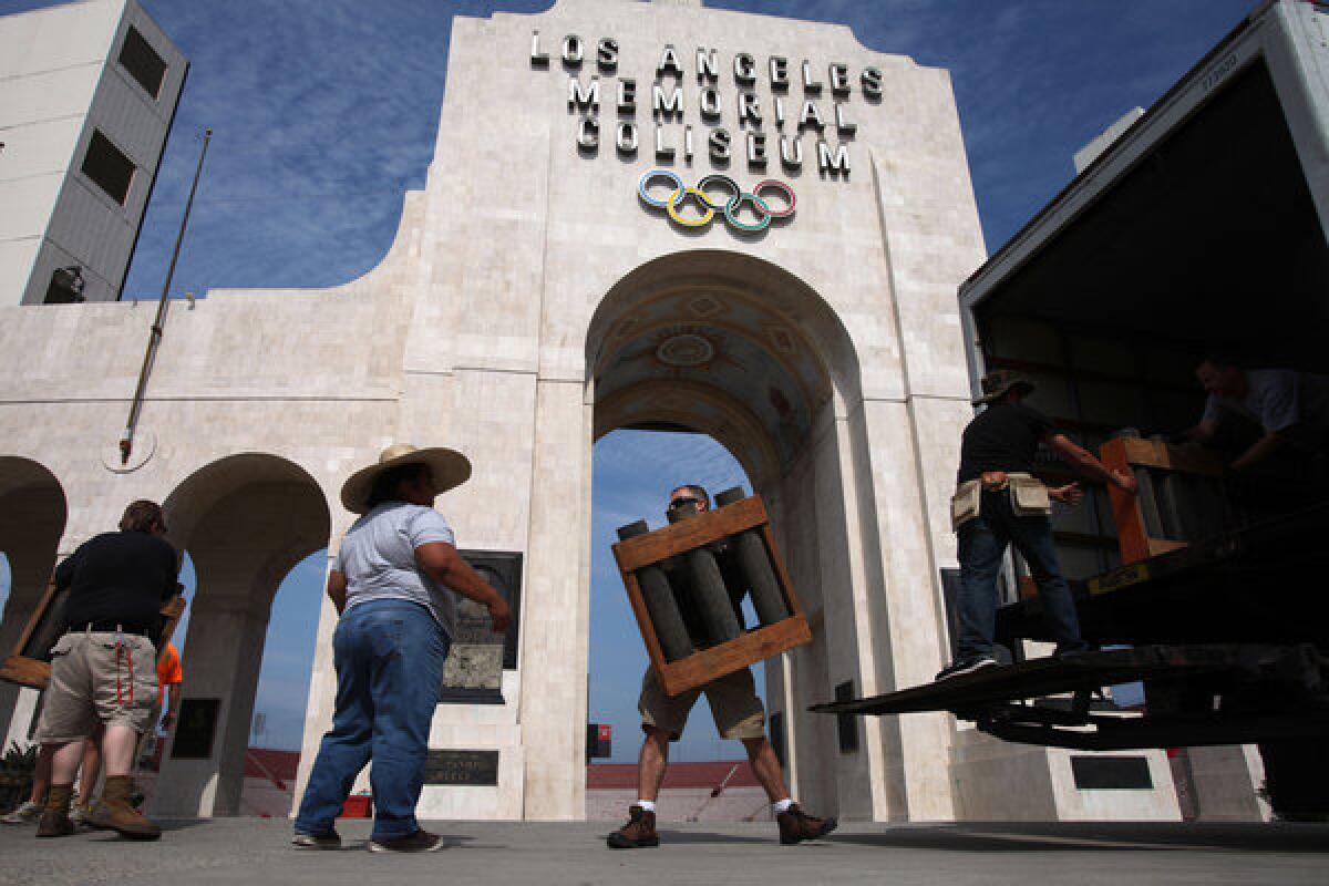 Pyrotechnic workers set up for this year's Fourth of July fireworks show at the Los Angeles Memorial Coliseum.