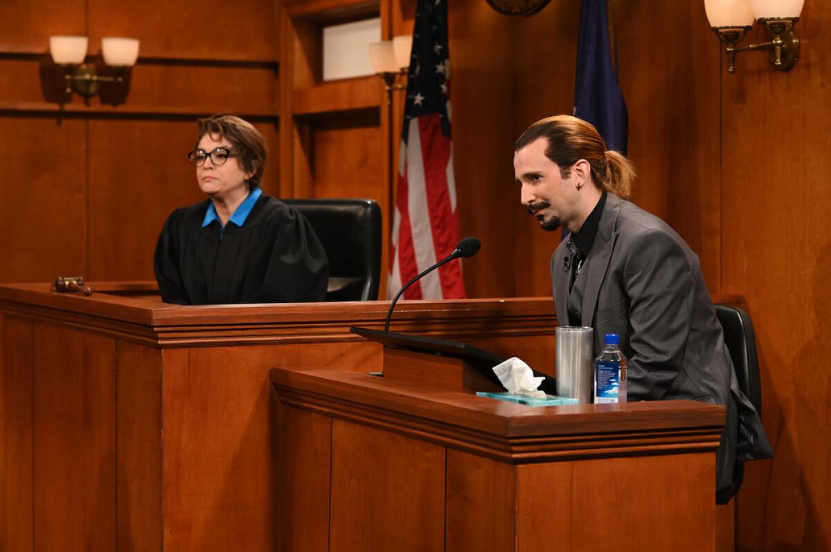 A woman dressed like a judge and a man dressed like Johnny Depp, seated in a courtroom