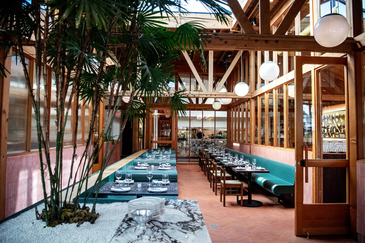 A dining area beneath exposed wood beams and a skylight.