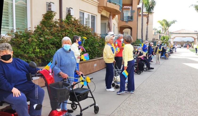 Residents of White Sands line an alleyway on the property to greet a family from Ukraine.