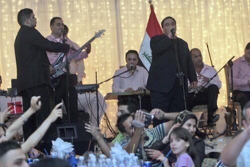 Baghdad residents enjoy a song by Qassim Sultan. As a Sunni, who is associated with Saddam Hussein's son Uday, Sultan feels wary on returning to Baghdad.